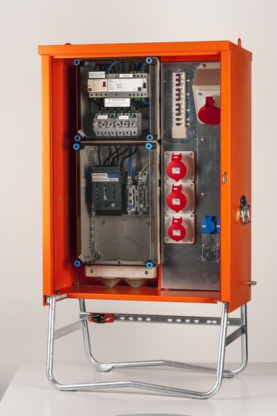 Ein Baustromverteiler der Marke metall-Meister mit der Körperfarbe Orange und drei Steckdosen 